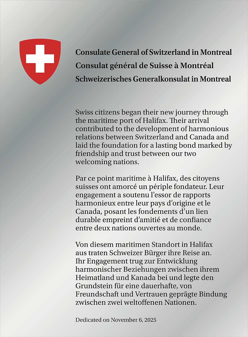 Plaque argentée brillante avec un écusson et un texte.