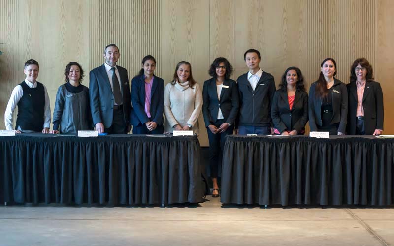 Un groupe d'adultes se tient derrière un long podium