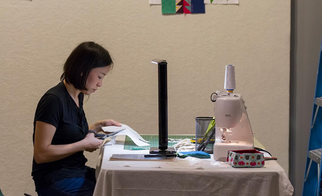 On voit une femme travailler dans une machine à coudre.