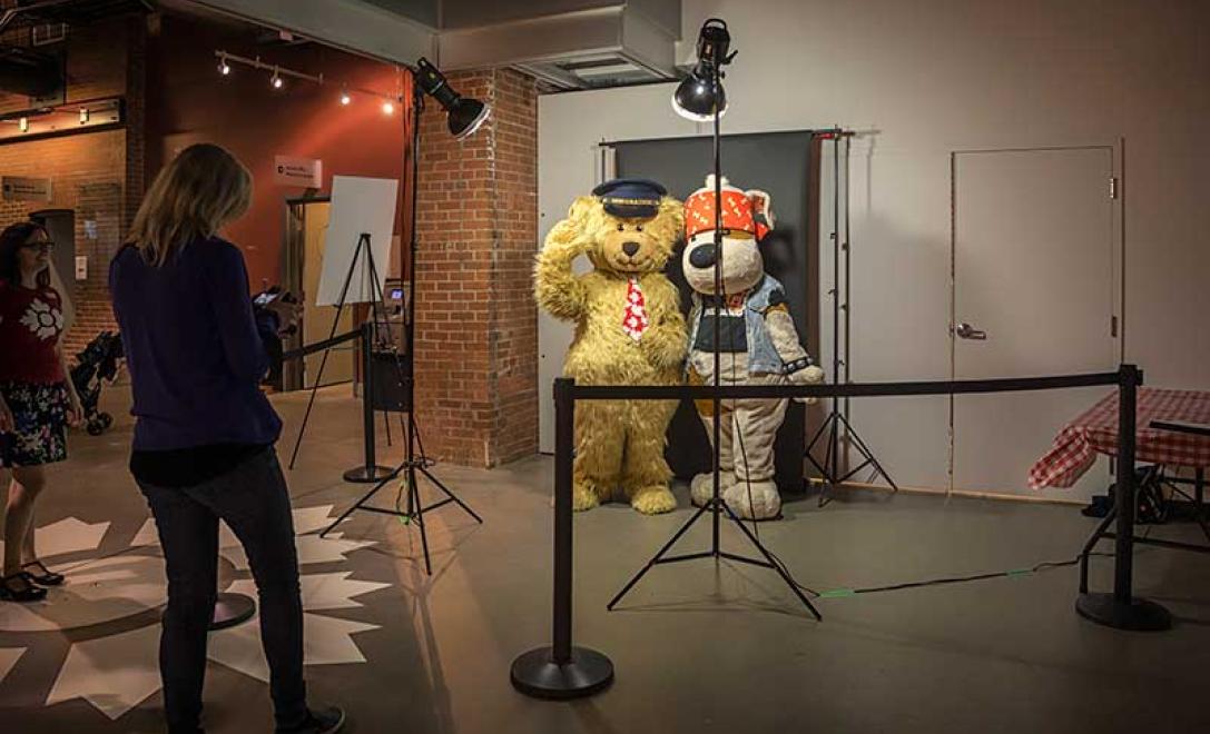 Une femme prend des photos de gens déguisés en mascotte.