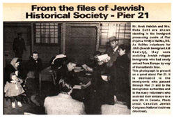 Un article intitulé « From the files of the Jewish Historical Society - Pier 21 » et une image de personnes autour d’un bureau.
