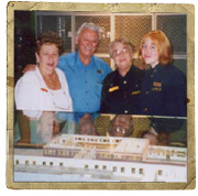 Quatre personnes posent ensemble derrière une vitrine de musée.