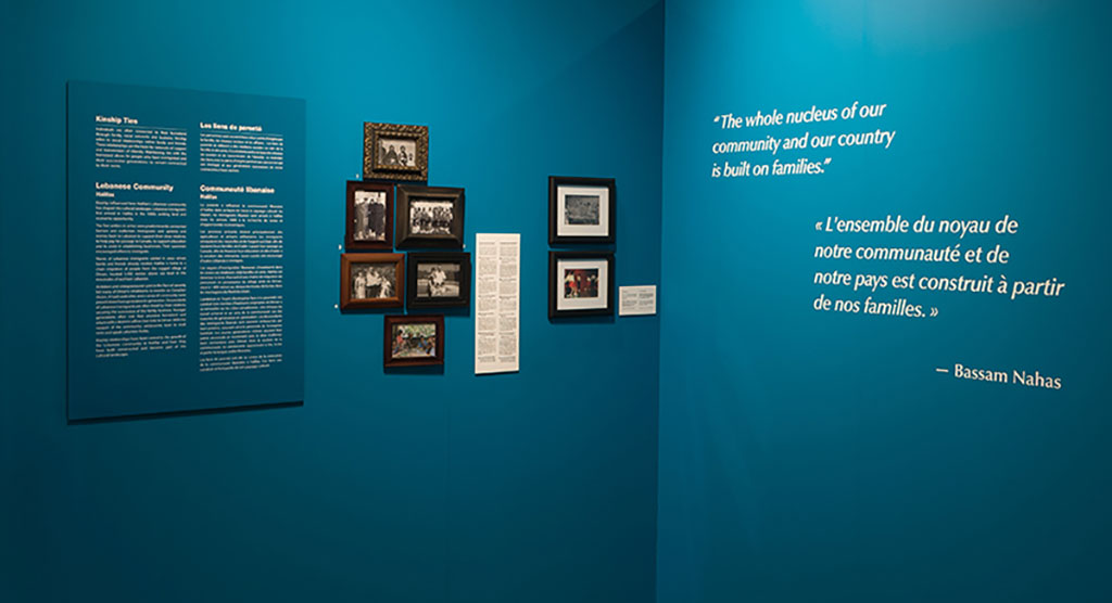 Deux sections d'un mur de couleur sarcelle. Des cadres dans lesquels se trouvent des images et du texte y sont accrochés.