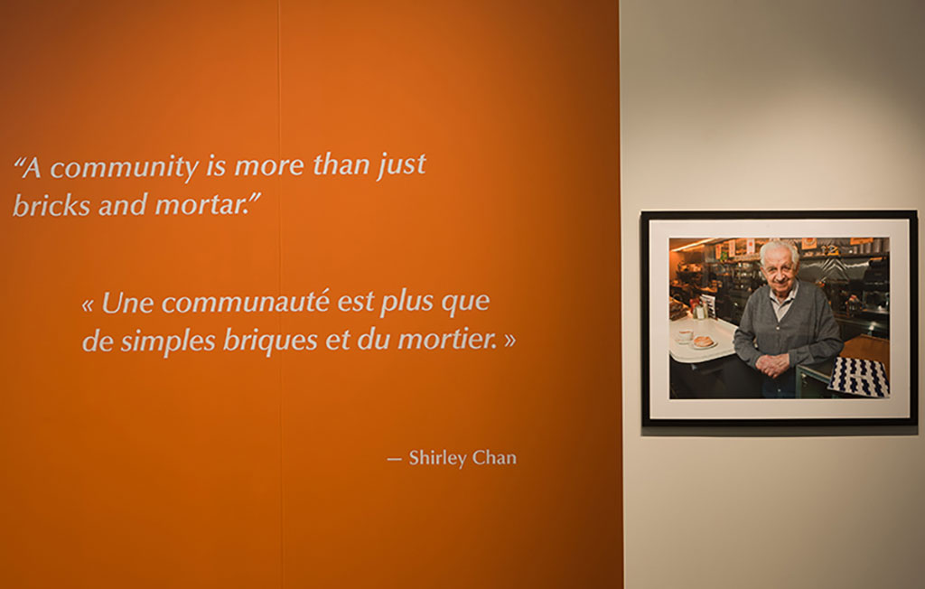 Un mur orange avec un portrait encadré d’un homme âgé.