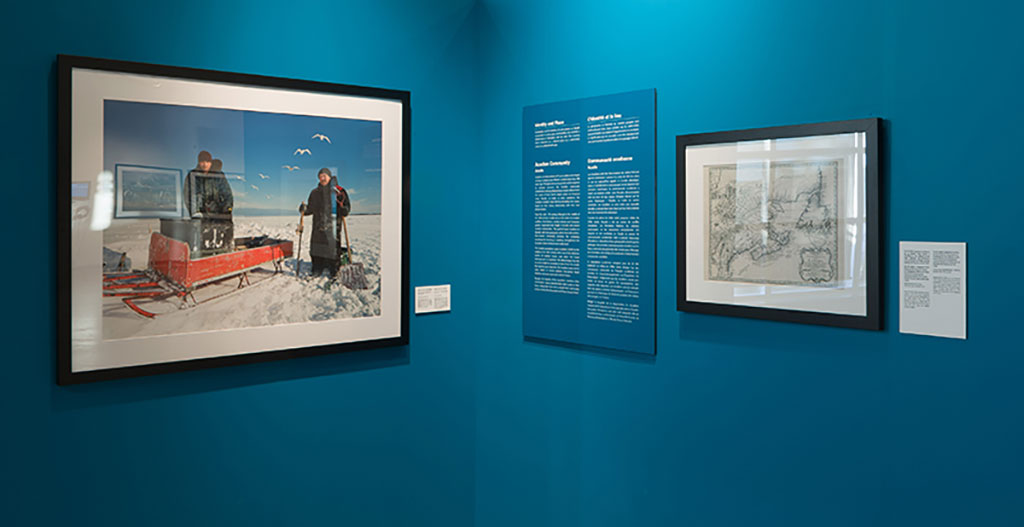 Un grand portrait de deux hommes debout dans la neige sur un mur turquoise.