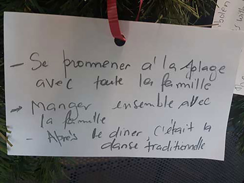 Un papier blanc accroché avec un ruban rouge.