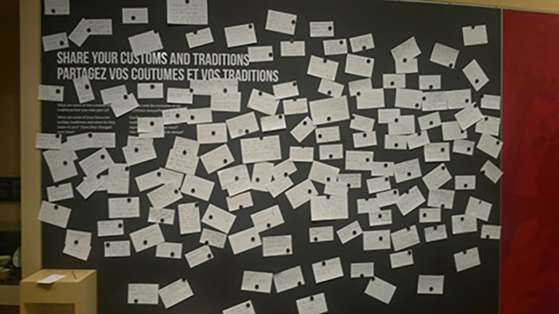Mur des coutumes et traditions; des papiers avec du texte manuscrit y sont accrochés avec des aimants.