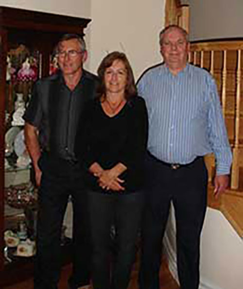 Deux hommes et une femme étant debout.