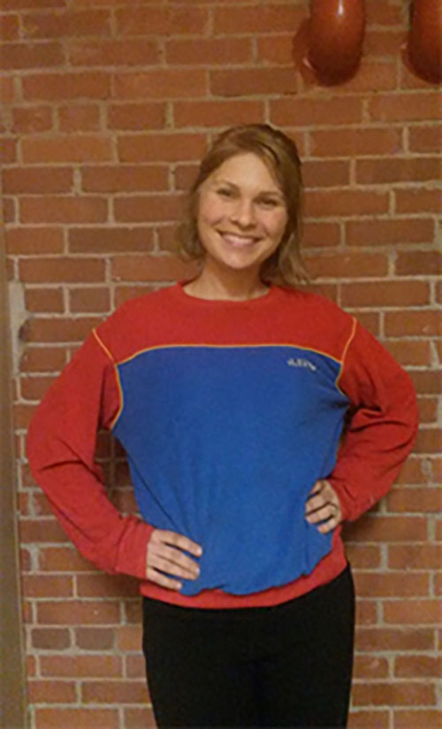Kristine Kovacevic , Gestionnaire de l’interprétation et de l’expérience du visiteur, portant un chandail rouge et bleu foncé.
