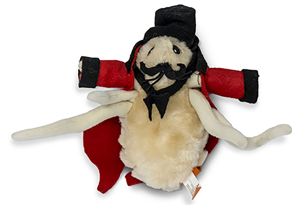 Un minuscule insecte en peluche avec des vêtements rouges et noirs et un chapeau noir.
