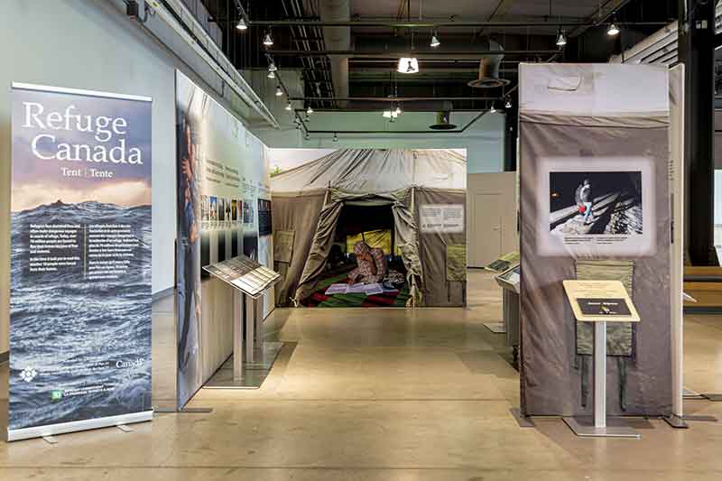 Bannière pop-up avec Refuge Canada écrit sur un fond de mer sombre et orageuse. Les panneaux sont configurés pour s'adapter à un petit plan d'étage.