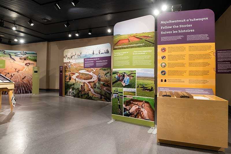 Espace d’exposition présentant des panneaux colorés avec texte et photos.