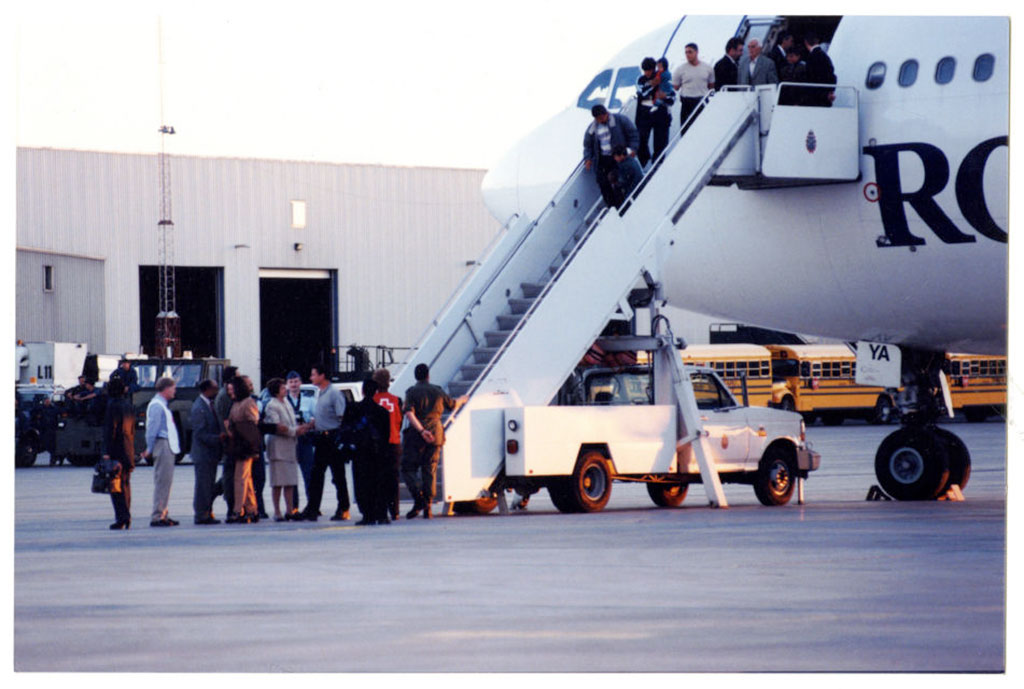 Plusieurs personnes débarquant d’un avion à l’aide d’un escalier.