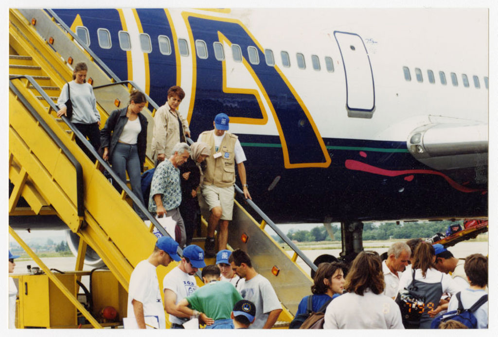 Plusieurs personnes débarquant d’un avion à l’aide d’un escalier.