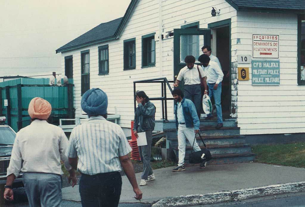 Un groupe d’hommes est vu quittant un petit bâtiment.