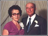 Couple d’âge mûr bien habillé et portant des fleurs à la boutonnière.
