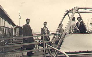 Famille vue du quai, marchant sur la passerelle d’embarquement d’un bateau.
