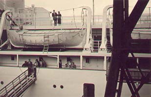 Passerelle d’embarquement et bateaux de sauvetage sur le navire, vus du quai.