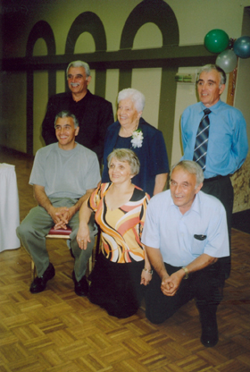 Six membres de la famille dans une grande salle décorée de ballons.