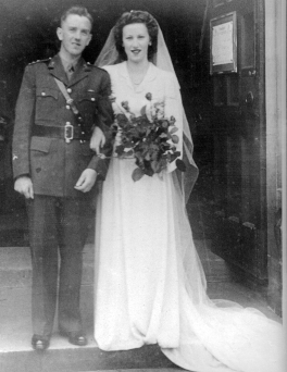 Les mariés Dwyer le jour de leur mariage, debout devant la porte.