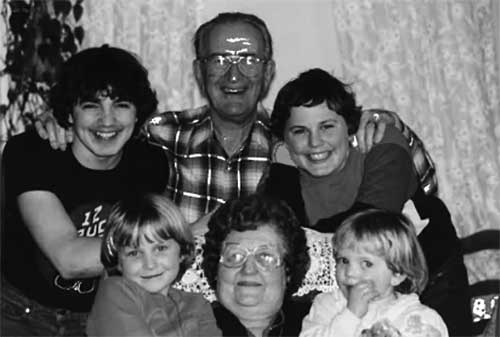 Un jeune couple assis avec leurs enfants. 