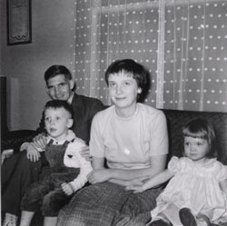 Jeune homme et femme assis sur un divan avec un petit garçon et une fille.