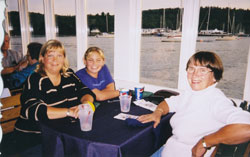 Irene, Fiona et Sarah assises à une table de restaurant avec une nappe mauve.