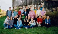 Photo de groupe avec plusieurs membres de la famille assis/debout sur l’herbe.