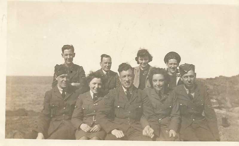 Un groupe de jeunes hommes et de jeunes femmes portant des uniformes militaires pose pour la caméra.