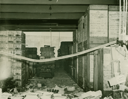 Photographie montrant les dommages à un entrepôt dans lequel on peut voir de grandes boîtes.