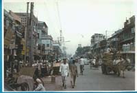 Rue animée de Delhi avec des gens et un caddie.