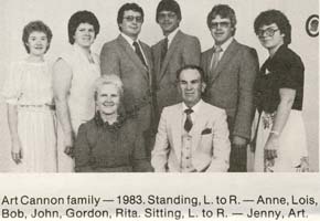 Photo de famille avec mère et père assis et six enfants debout derrière eux.
