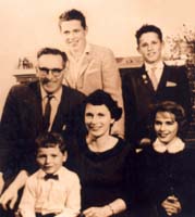 Vieux portrait de famille, une mère assise, le père et les enfants autour d’elle.