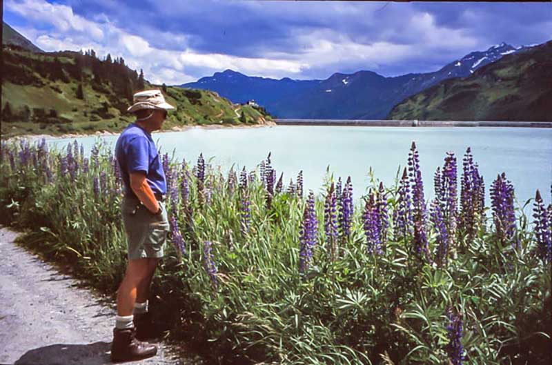 Un homme en tenue d’été regarde un beau lac.