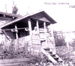 Vieille photographie d’une femme regardant à l’extérieur depuis le porche d’une maison.