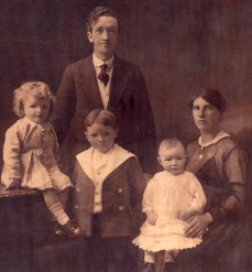 Portrait en ton sépia d’une mère, d’un père et de trois petits enfants.