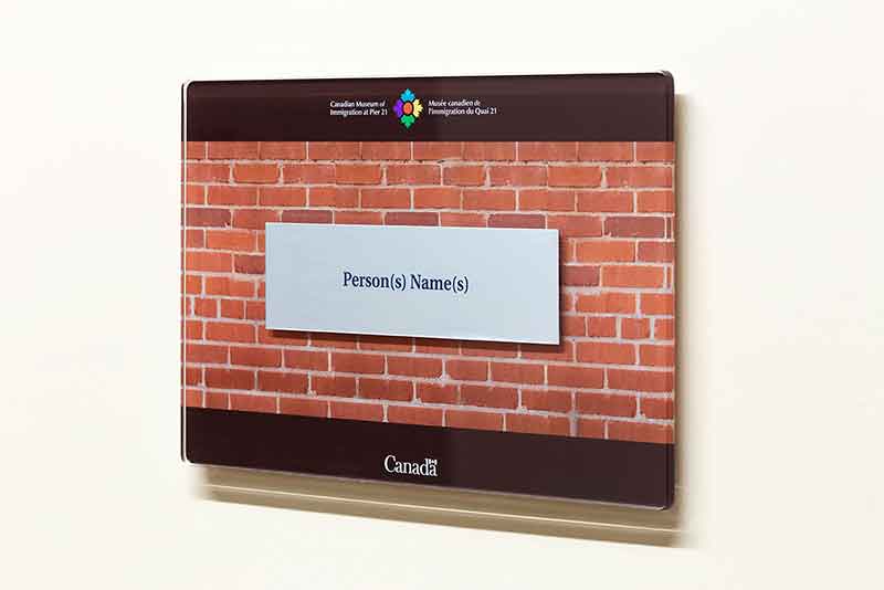 Une plaque en argent avec une inscription type est encastrée dans une plaque transparente.
