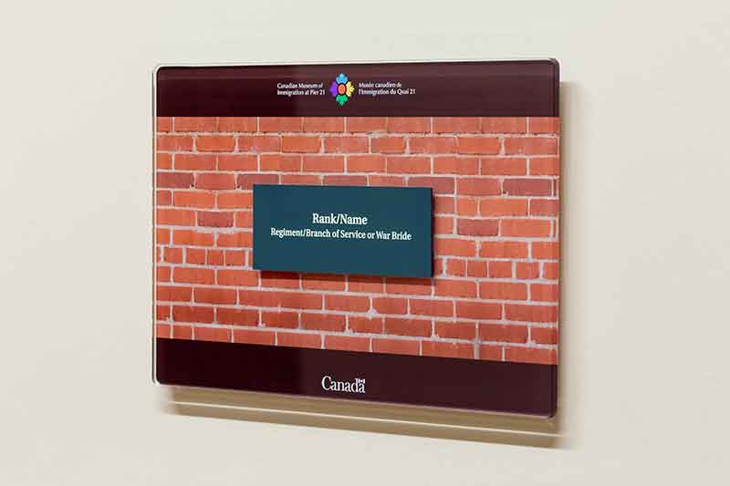 Une plaque verte avec une inscription type est encastrée dans une plaque transparente.
